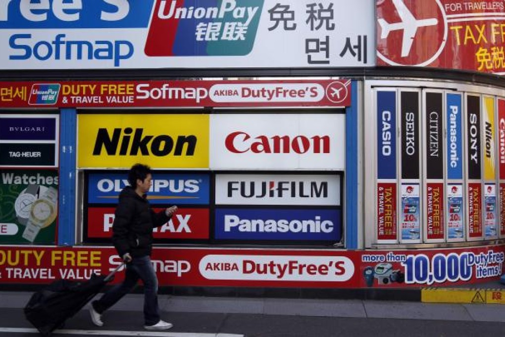 A man passes a hoarding advertising UnionPay in Akihabara shopping district in Tokyo. Photo: Reuters