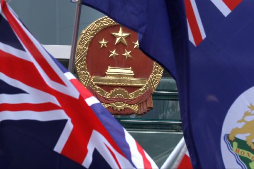 Members of "We are Hongkongers, Not Chinese" wave Hong Kong Flag of the colonial era in front of Central Government's Liason Office. Photo: Dickson Lee