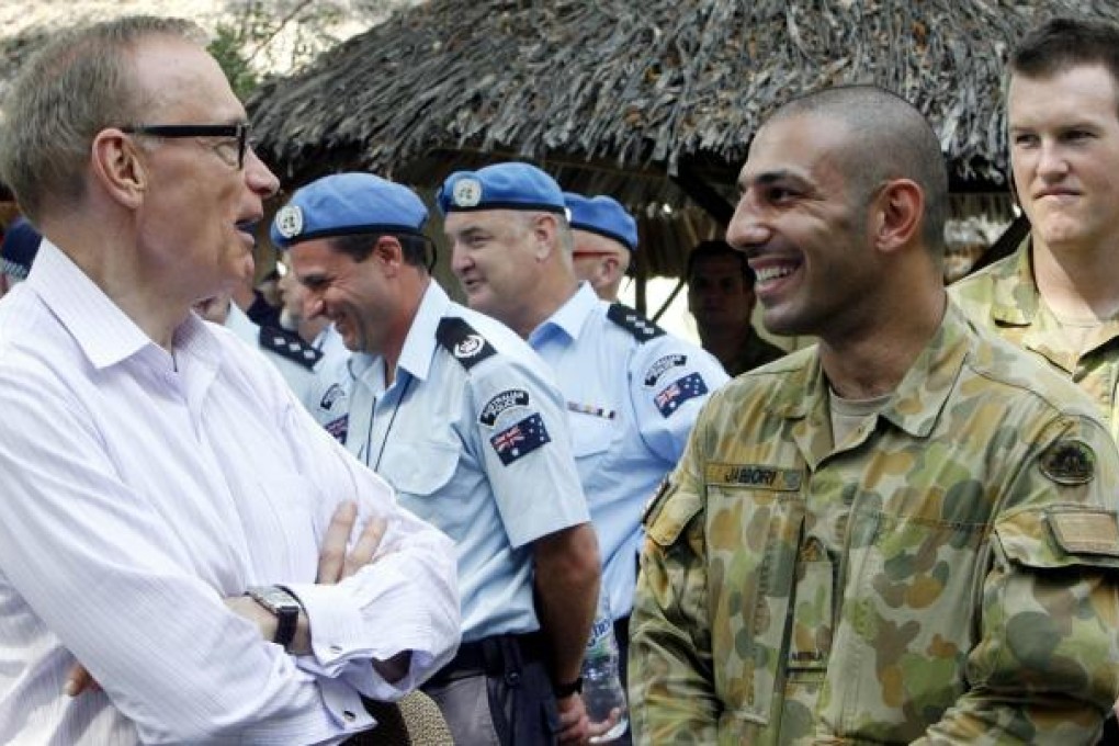 Australian Foreign Minister Bob Carr talks to Australian officers during a visit to their headquarters in Dili on Friday. Photo: EPA