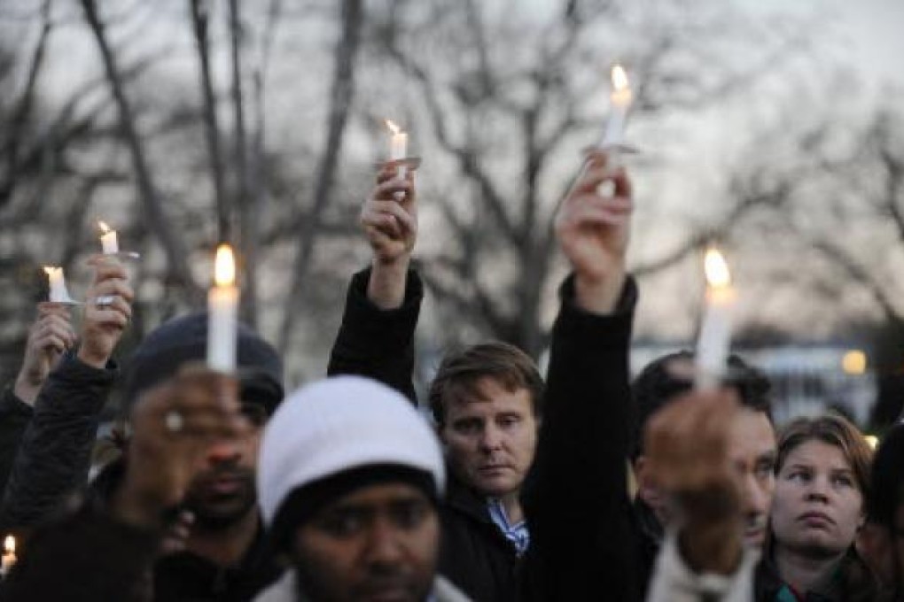 Supporters of gun control legislation hold candles during a rally to pay respect for the shooting victims in front of the White House in Washington, capital of the United States, Dec. 14, 2012. Photo: Xinhua