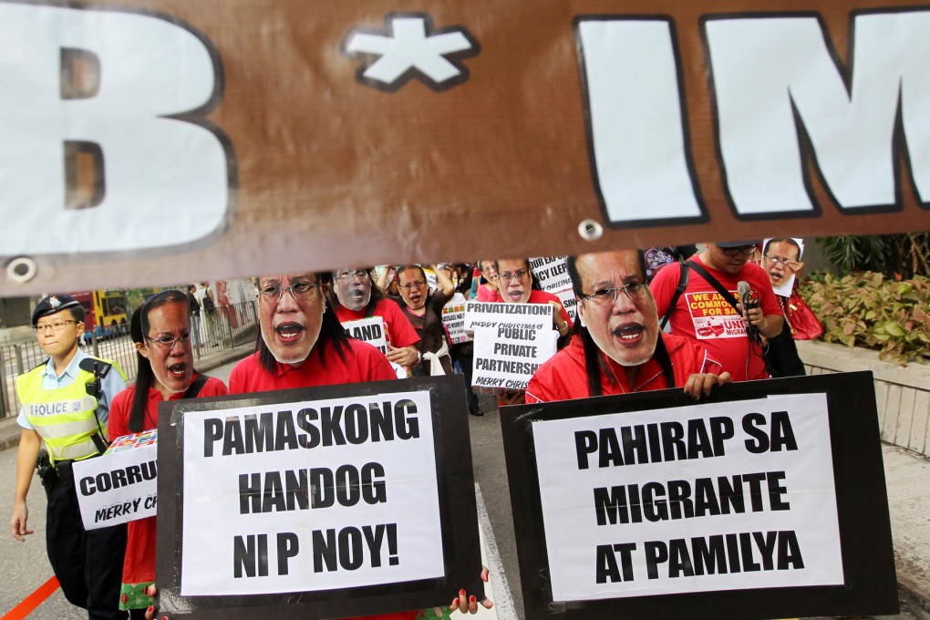 Maids wearing masks bearing the face of Philippines President Benigno Aquino take part in a labour rights protest. Photo: Sam Tsang
