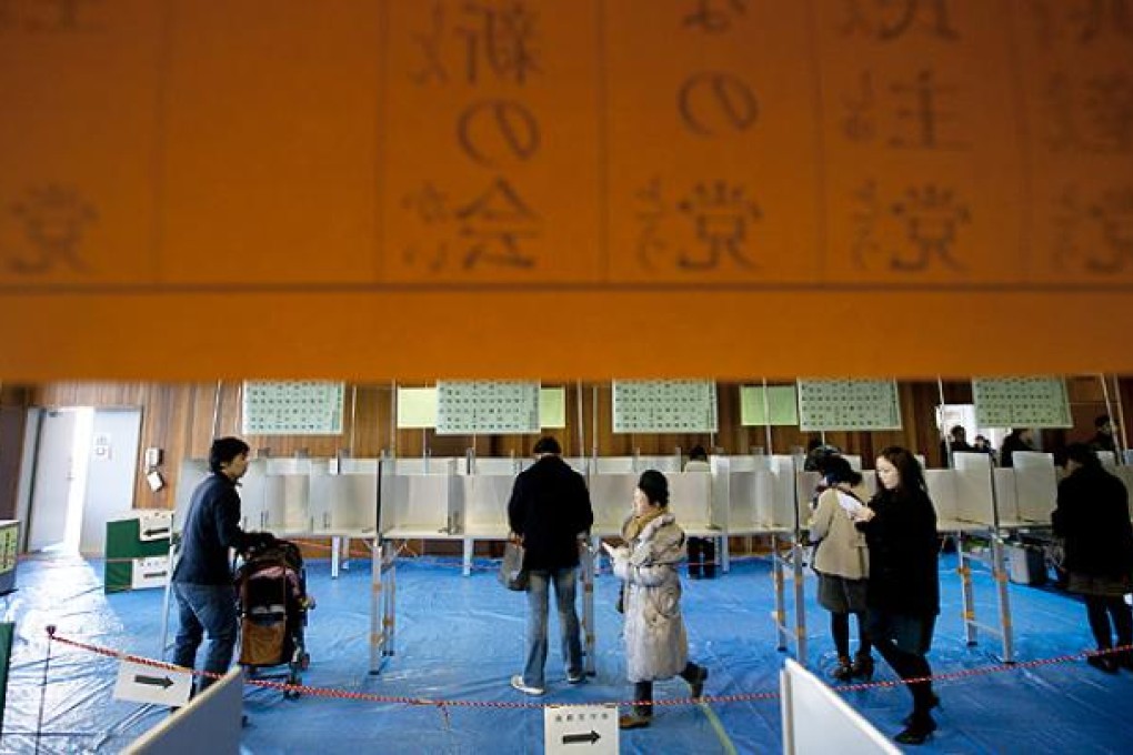 Voters fill out ballots at a polling station at a polling station in Tokyo on Sunday. Photo: Bloomberg