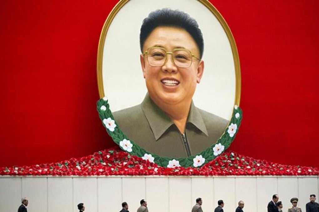 North Korean leader Kim Jong-un (right) arrives with other top leaders under a portrait of his late father Kim Jong-il as they attend a national meeting on the eve of the anniversary of Kim Jong-il's death, in Pyongyang, North Korea, on Sunday. Photo: AP