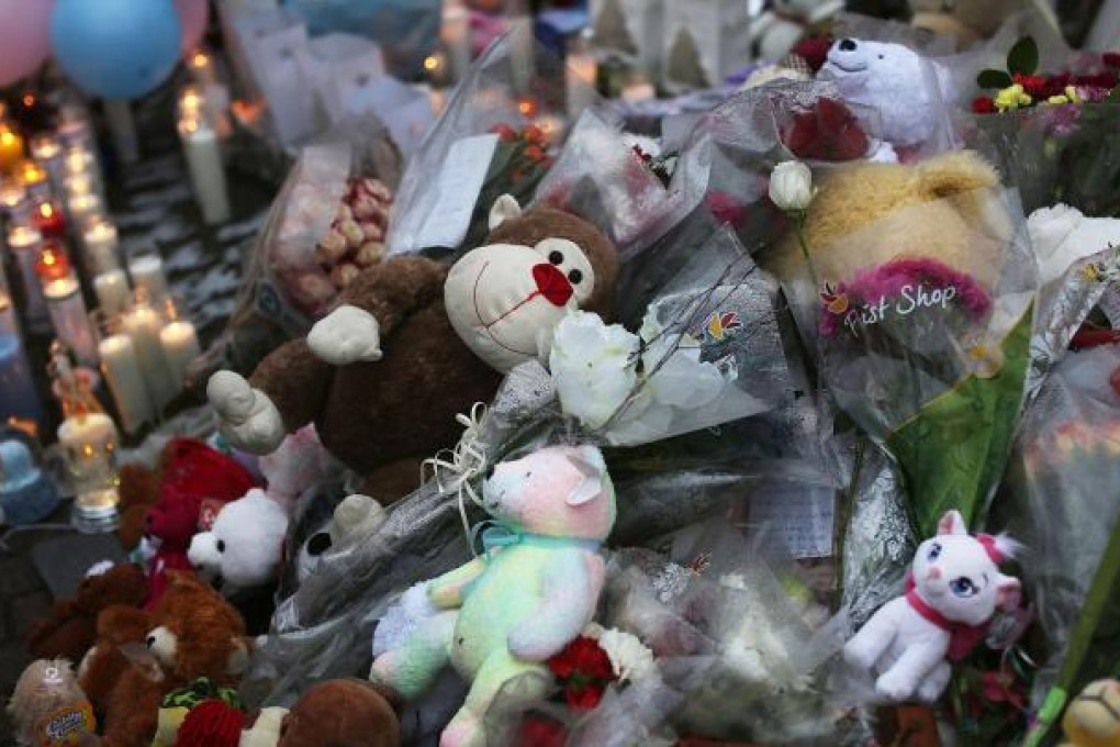 Teddy bears, flowers and candles at one of many makeshift memorials in Newtown. Photo: AFP