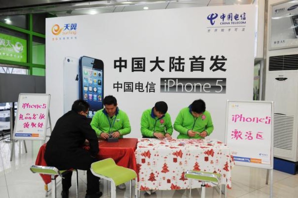 Staff members from China Telecom, serve an iPhone 5 buyer in Beijing on Friday, Dec. 14, the day of the launch. Photo: Xinhua