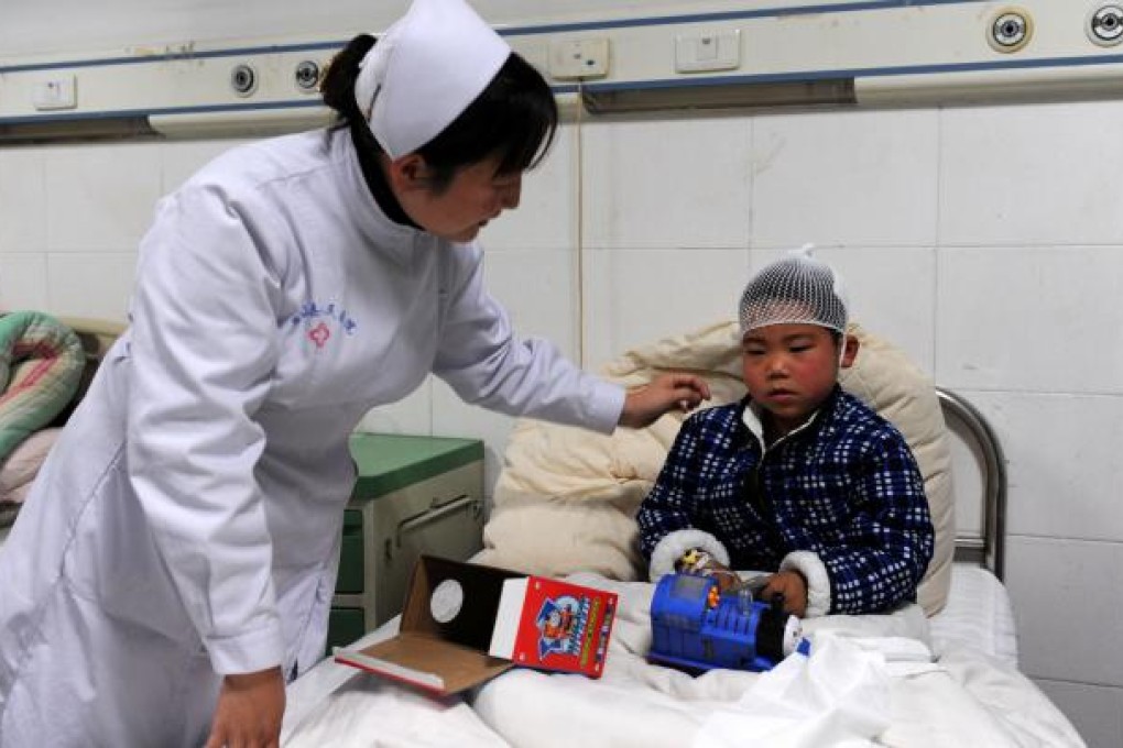 Xie Xinye, a primary school student injured in the knife attack, receives medical treatment in a hospital in Guangshan County, Henan. Photo: Xinhua