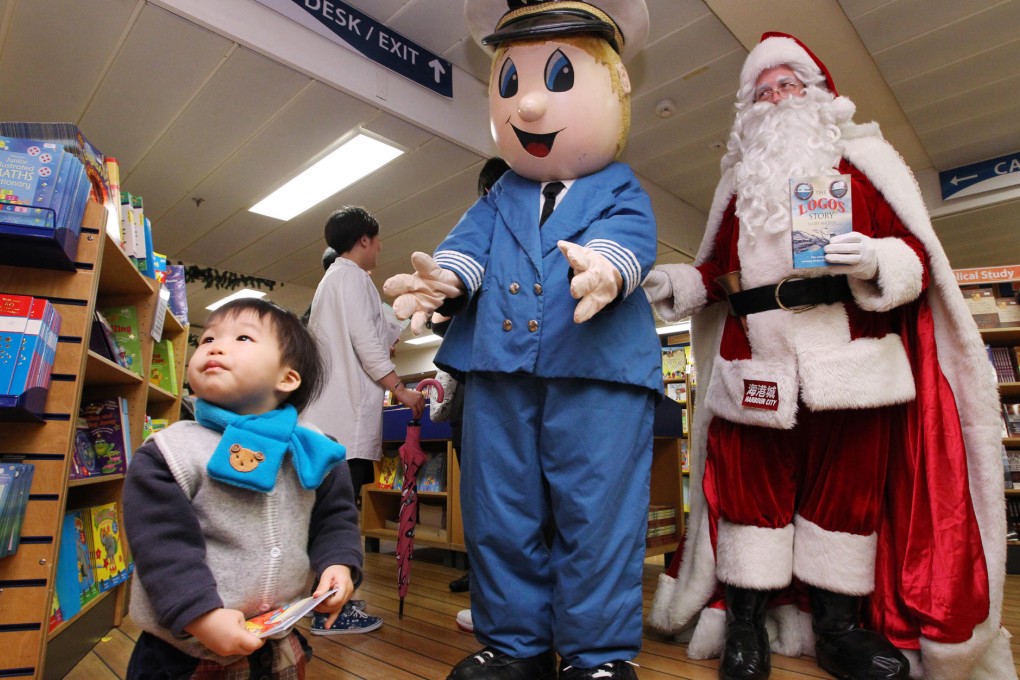The Logos Hope mascot and Santa Claus welcome a young shopper to the book sail, which boasts over 5,000 tomes. Photos: Nora Tam