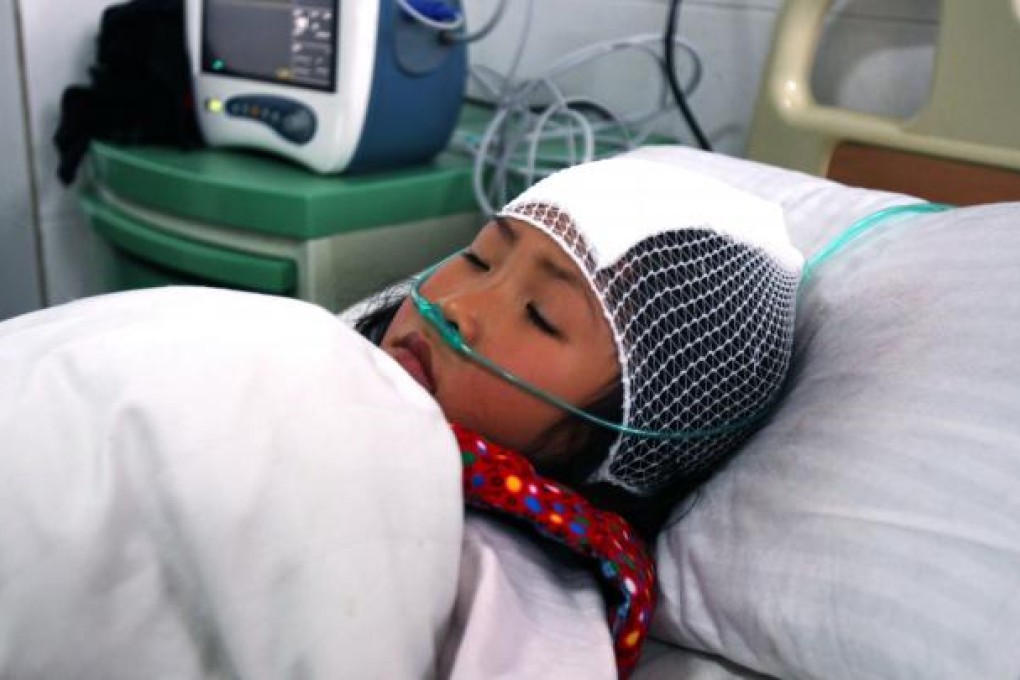 A girl lying on a hospital bed after she was stabbed during a knife attack that took place in a primary school in Henan. Photo: AFP