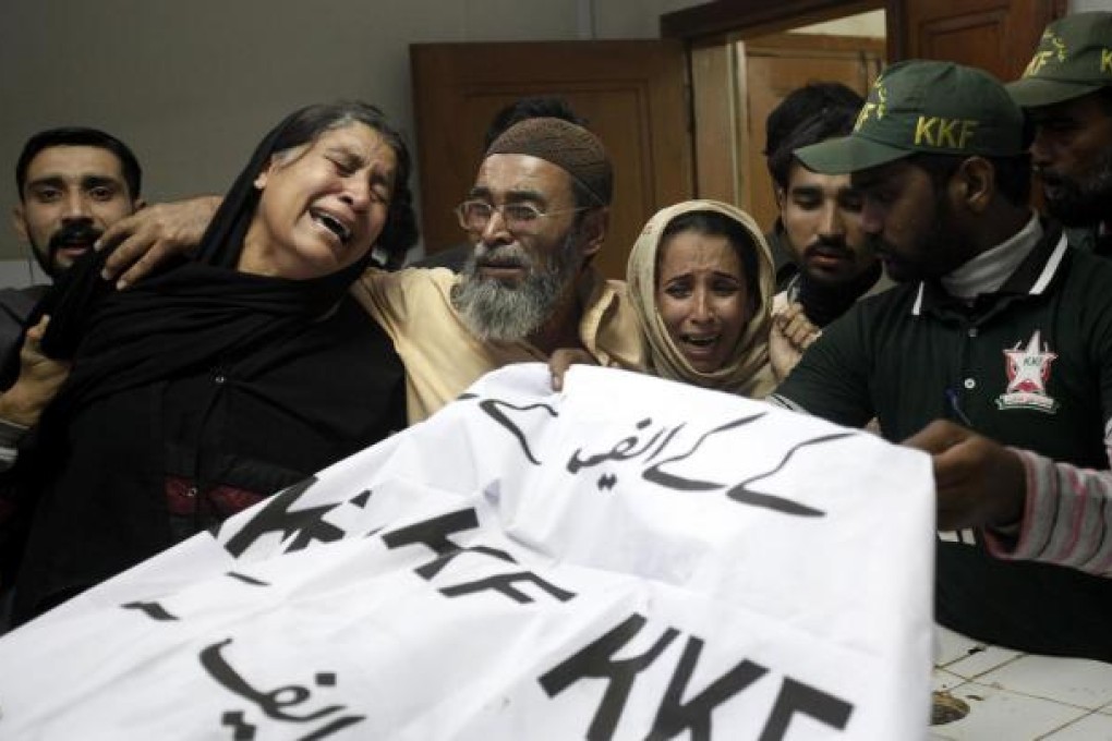Relatives grieve over a female polio worker's body. Photo: Reuters