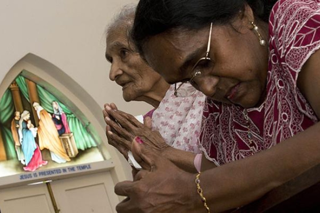 Christian worshippers pray in front of a window panel at the Church of Our Lady of Lourdes, in the port town of Klang, on the outskirts of Kuala Lumpur. Photo: AFP