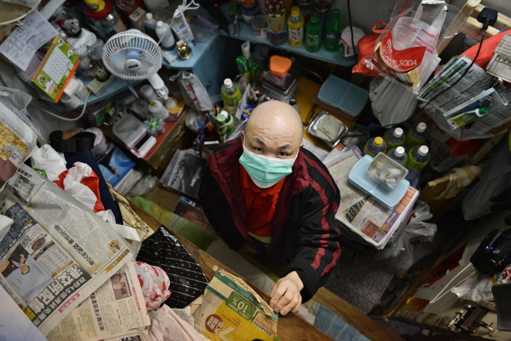 People stuck living in tiny cubicles like this man will often be charged higher than normal power rates by landlords. Photo: Thomas Yau