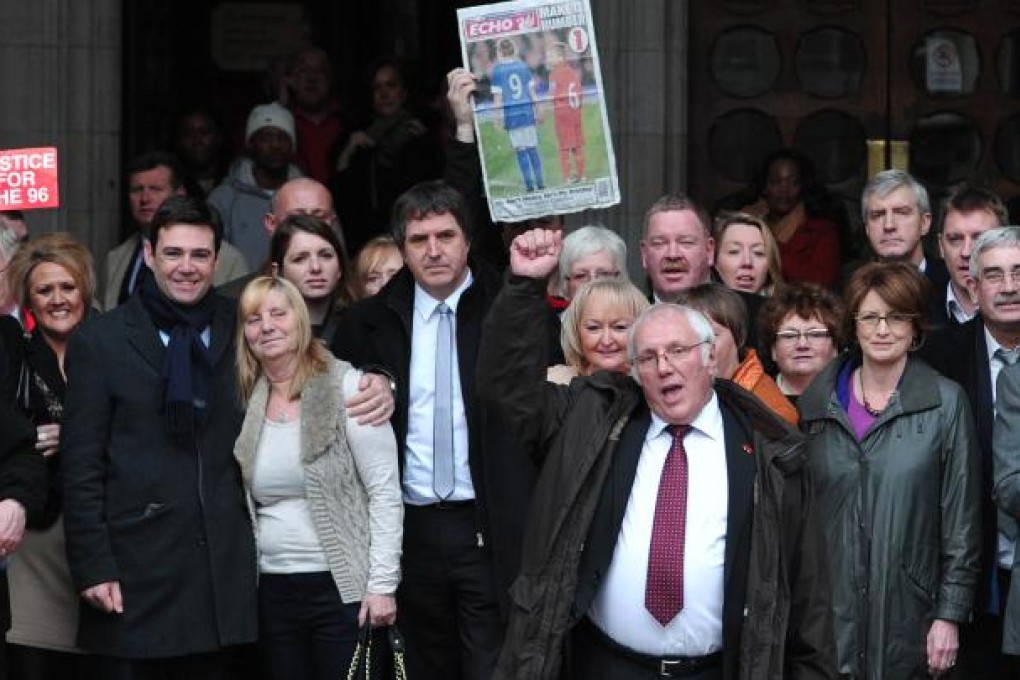 Trevor Hicks and other supporters pose outside the High Court in central London, after the High Court quashed the original accidental death verdicts returned on 96 Liverpool football fans who died in the 1989 Hillsborough disaster. Photo: AFP