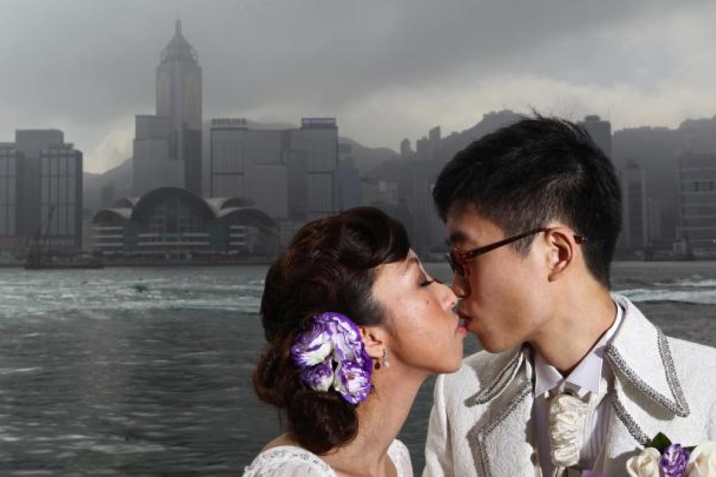 Ling Tsang (left) and Kit Wong seal their union with a kiss in Tsim Sha Tsui. Photo: Nora Tam