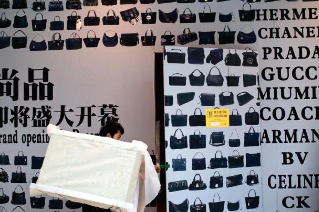 A worker furnishing a new luxury goods store in Beijing. Photo: AP
