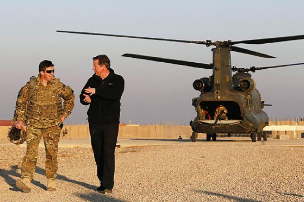 Britain's Prime Minister David Cameron (right) arrives during a visit to Forward Operating Base Price in Helmand province, Afghanistan on Thursday. Photo: AFP
