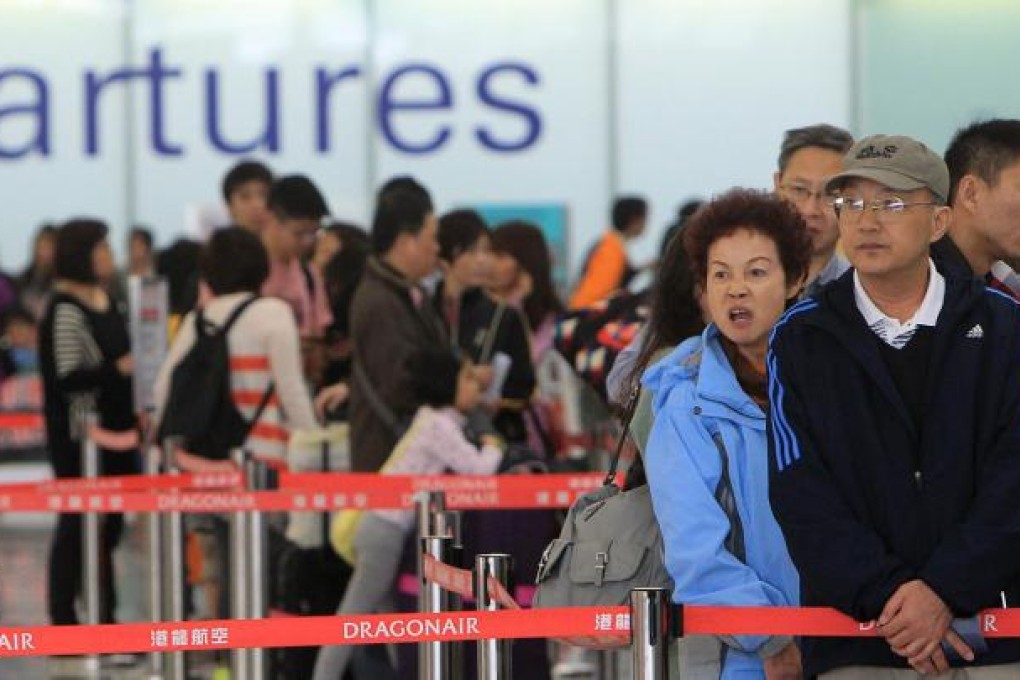 Arriving and departing passenger traffic was busy but orderly at Hong Kong International Airport yesterday as the Christmas holidays began in earnest. Today will be the busiest day, with 1,067 flights scheduled, while almost 18,500 flights will be handled over the two weeks until January 7. Photos: Jonathan Wong