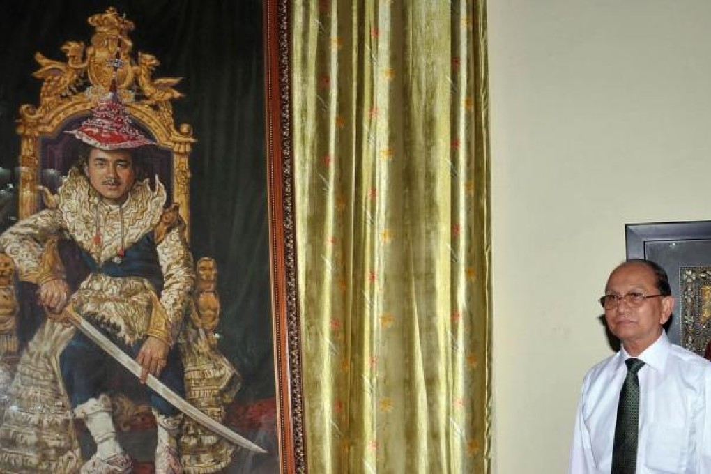 Thein Sein stands next to a photograph of King Thibaw. Photo: AFP