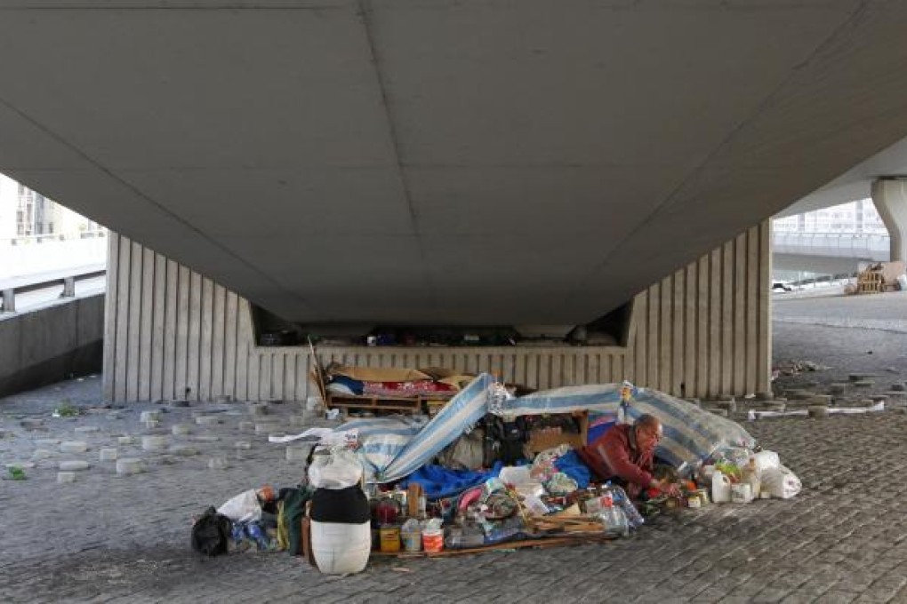 An elderly man sleeping rough prepares for Christmas under the West Kowloon Corridor in Yau Ma Tei. Photo: Nora Tam