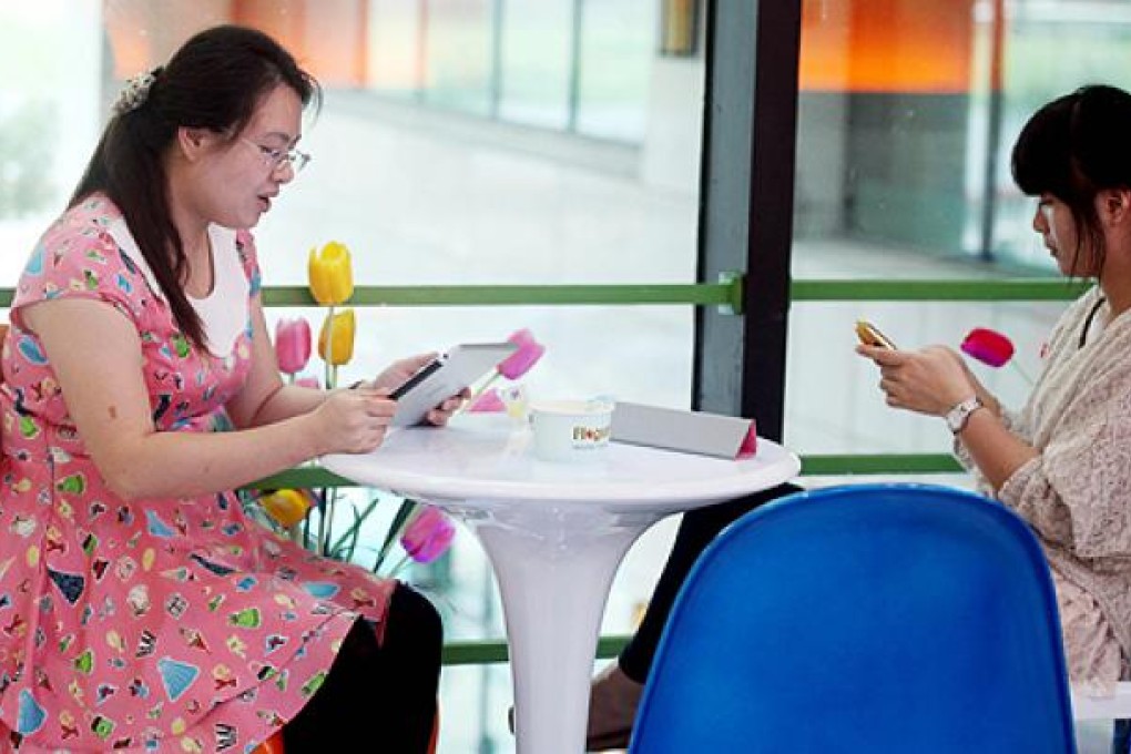Women use the internet in a restaurant in Haikou, China. Photo: AFP