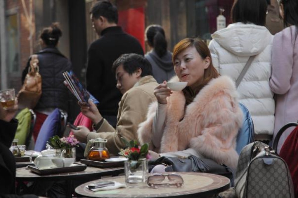 A woman sips tea in Tianzifang, Shanghai. Up to 200 million city dwellers have no residency status. Photo: Corbis