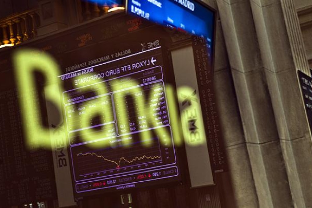The Stock Exchange main display is reflected on a Bankia sign in Madrid. Photo: AP