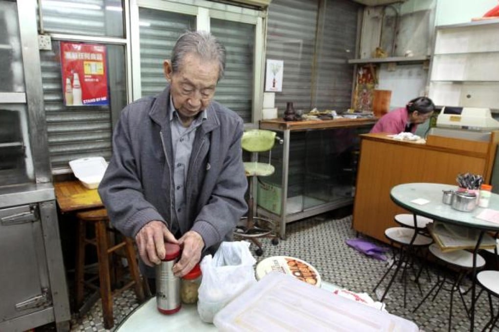 Chan Gui-chou, 91, owner of the Kam Kee Café in Shau Kei Wan, clears up after closing the doors for the last time. The restaurant has served locals for four decades but is the latest victim of skyrocketing rents. Photo: Dickson Lee