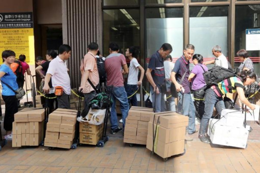 Parallel traders are seen outside Sheung Shui MTR station with their goods. Photo: David Wong