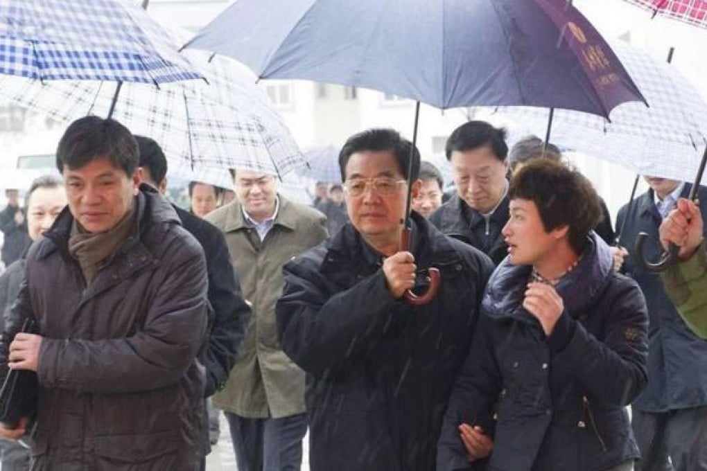 Hu Jintao holds an umbrella for a village official while visiting Yancheng, Jiangsu. Photo: SCMP