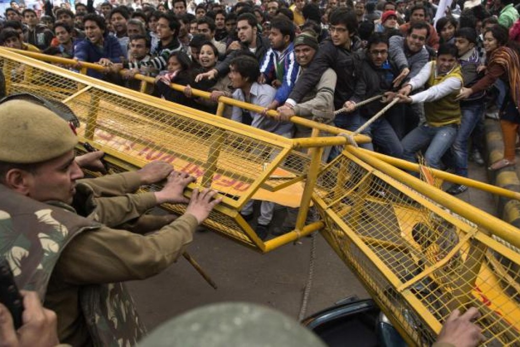 Protesters try to pull away a police barricade in New Delhi yesterday amid outrage at the gang rape and murder of a student. Photo: Reuters