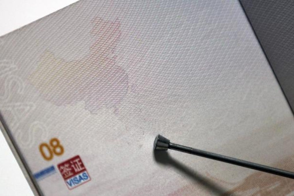 Pointer indicates where disputed islands and territorial waters are situated in the map of China on Chinese passport that includes the South China Sea. Photo: EPA