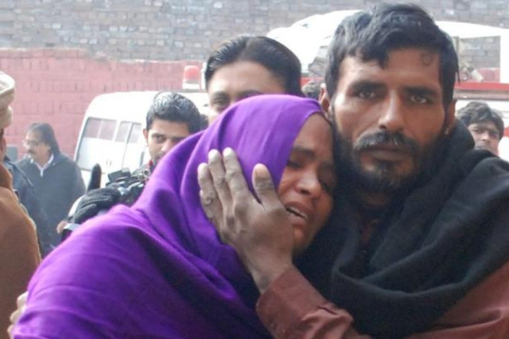 Relatives of cough syrup victims collect the bodies. Photo: EPA