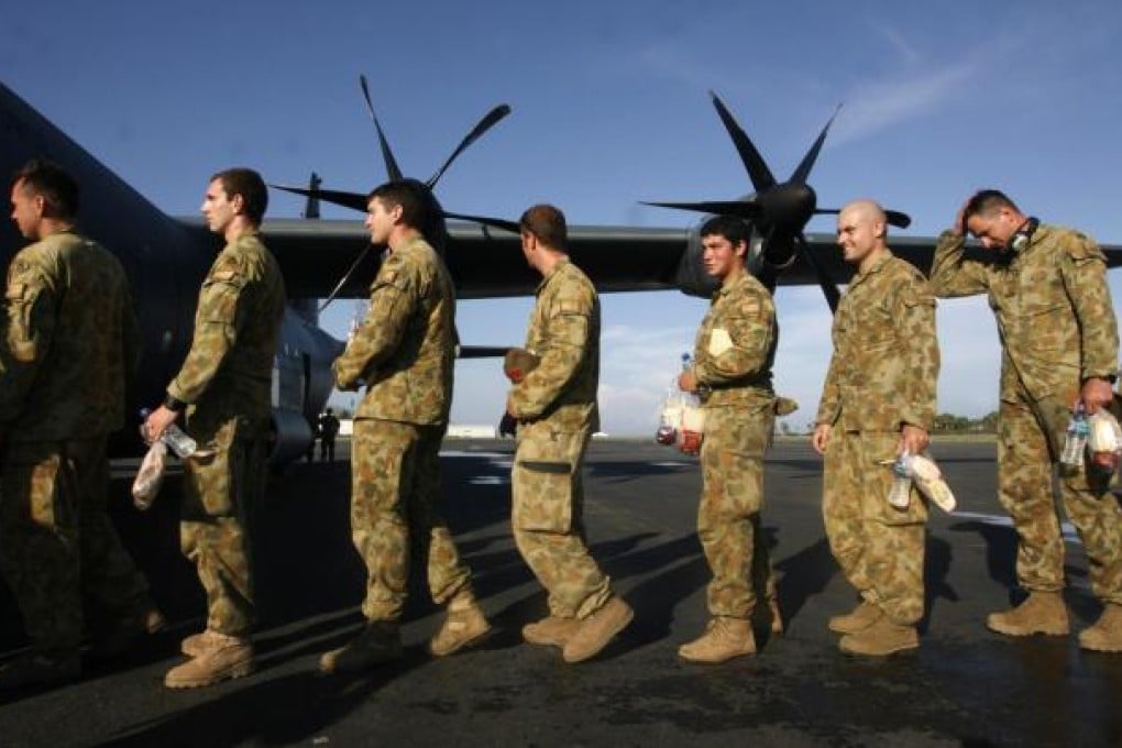 Australian soldiers with the International Stability Force in East Timor queue up to board a flight home. Photo: Reuters