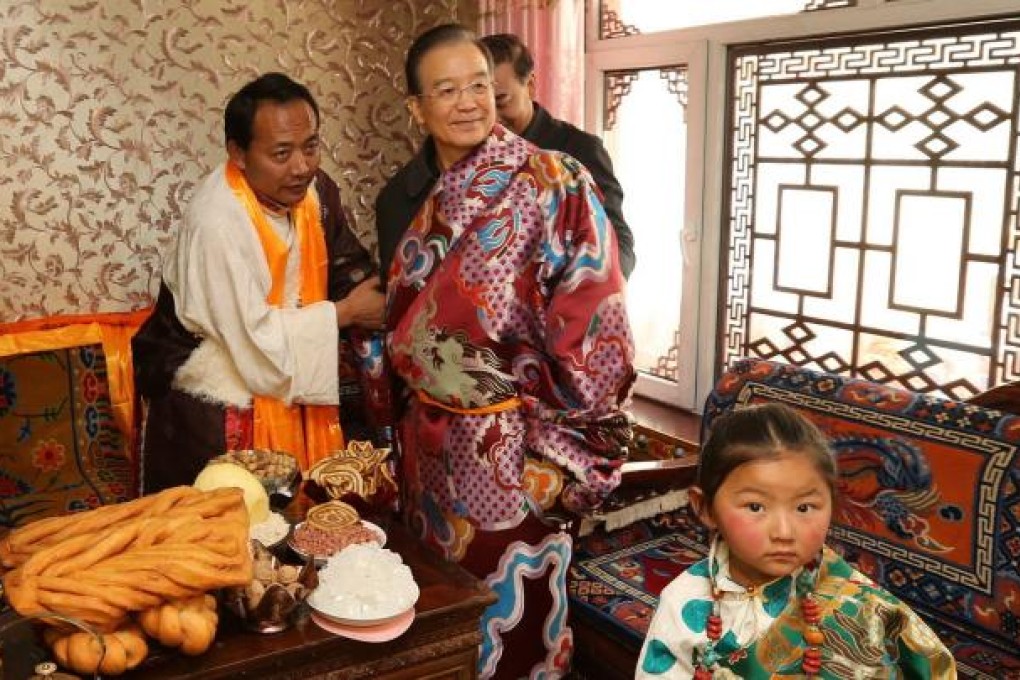 Premier Wen Jiabao tries on a Tibetan costume at a home in Yushu. Photo: Xinhua