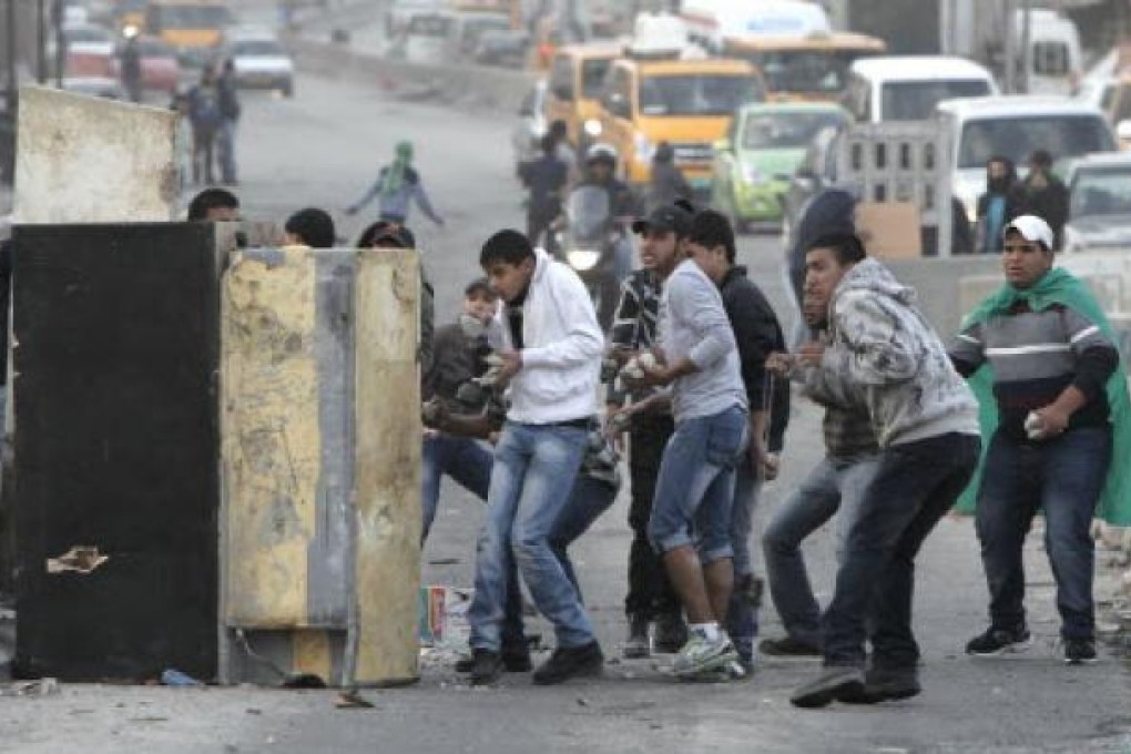 Palestinian youth clash with Israeli soldiers in the occupied territories late last year. On Monday, Israel dropped its five-year ban on construction materials crossing into the territory. Photo: Reuters
