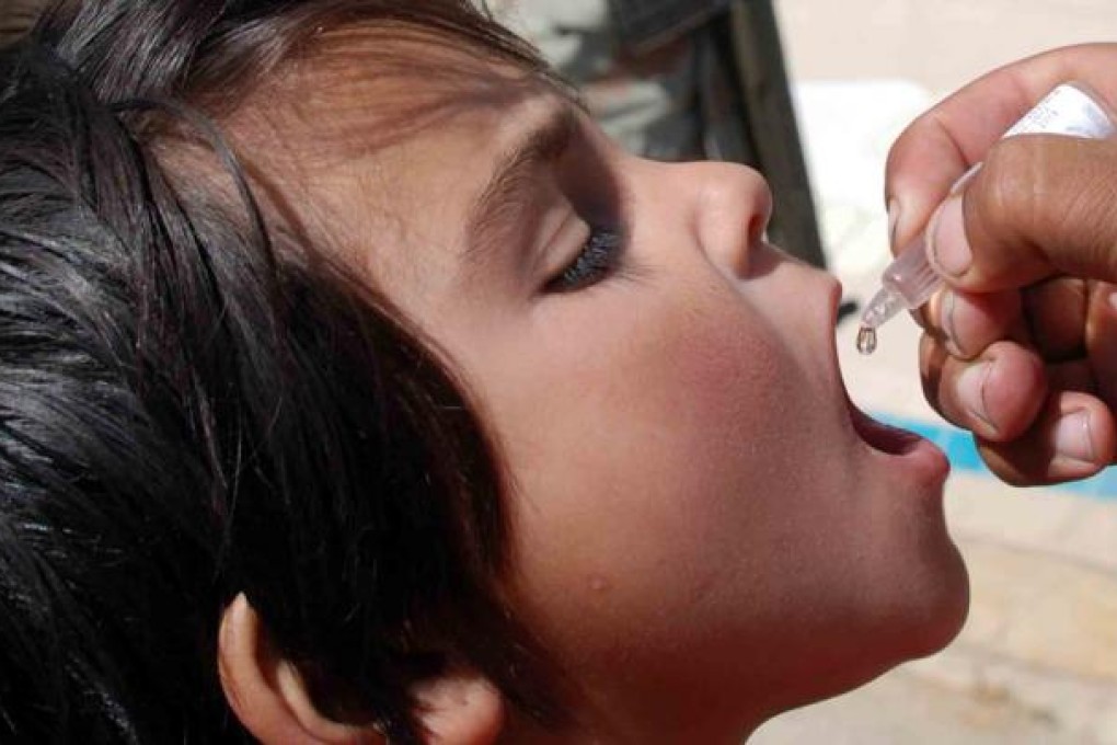 A health department worker applies a polio vaccine dose to a child in Peshawar, Pakistan. Photo: EPA
