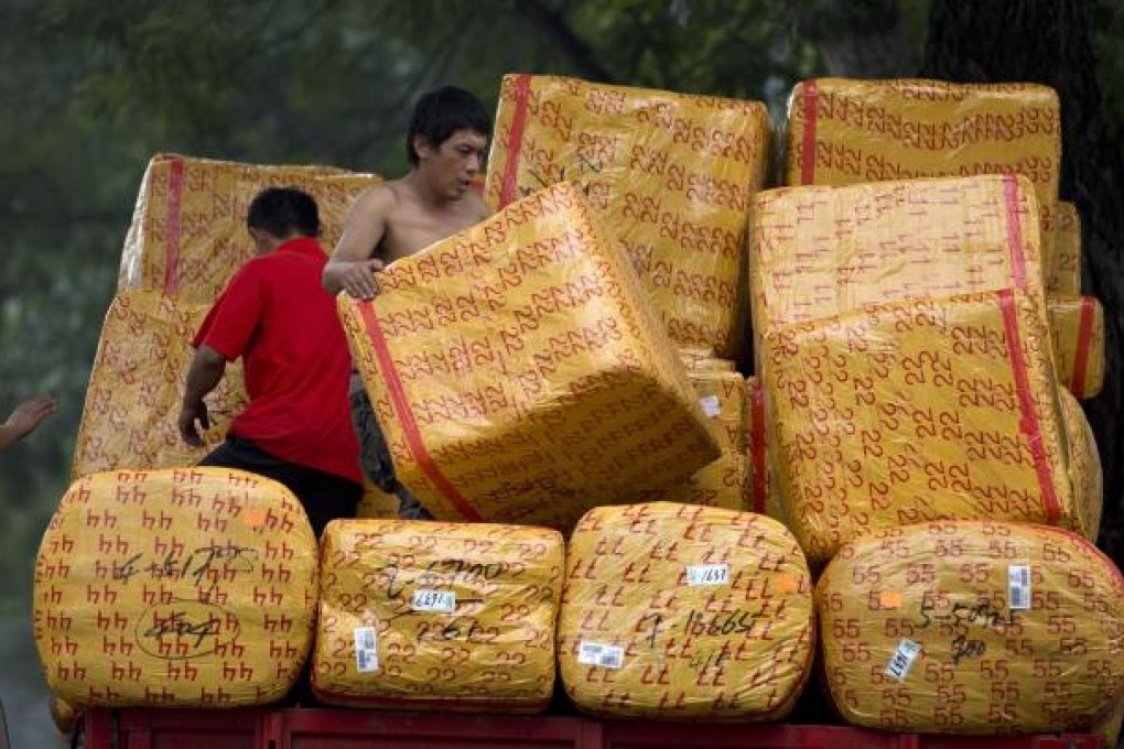 Workers loading their truck near a wholesale clothing market in Beijing. The country's new leaders are expected to maintain a loose policy stance to grow the economy. Photo: AP