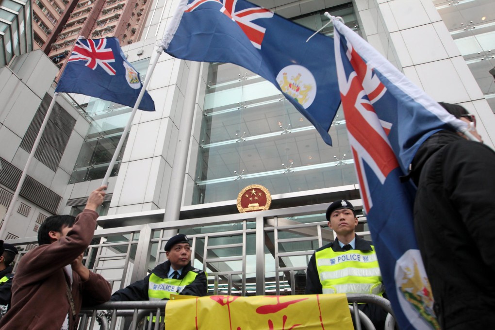 Protesters display Hong Kong colonial flags outside the liaison office on Tuesday. Photo: SCMP