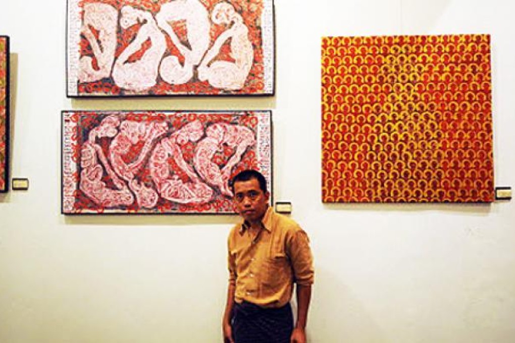 Myanmar artist Htein Lin in front of one of his paintings during an exhibition in Yangon. Photo: AFP