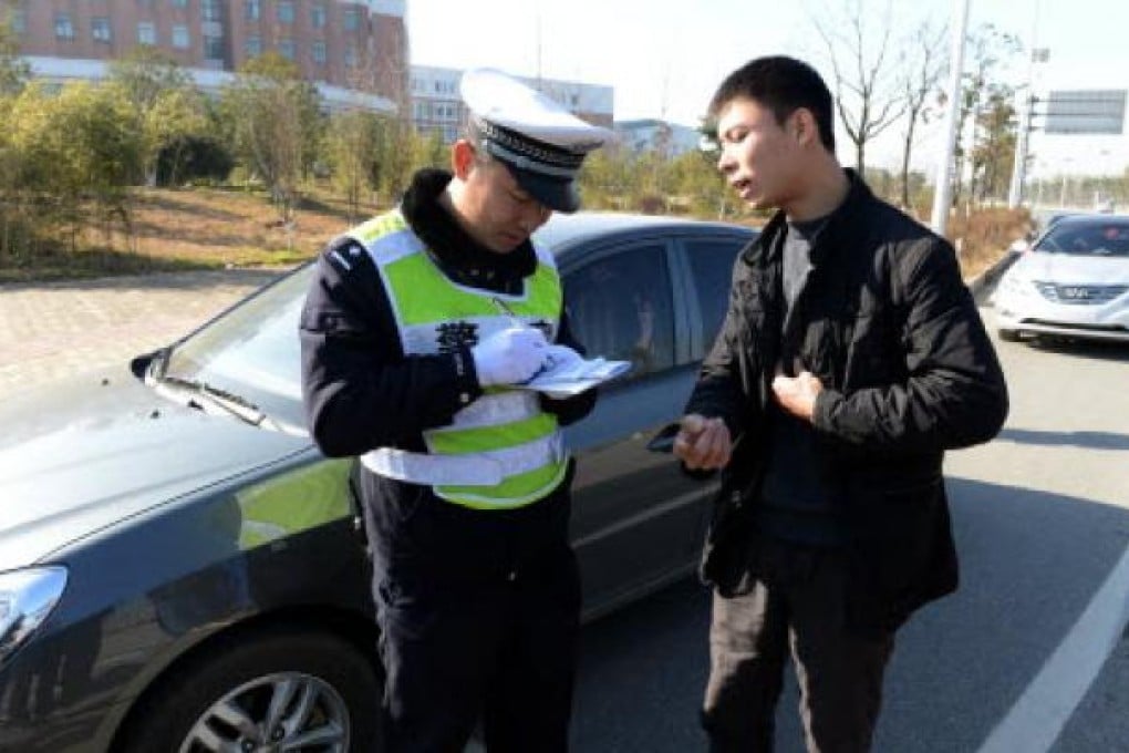 A driver receives a ticket for a traffic violation in Nanchang, Jiangxi province, on Tuesday. Photo: Xinhua