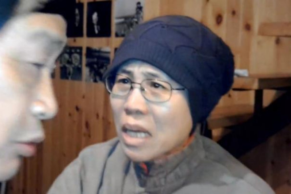 Liu Xia, wife of 2010 Nobel Peace Prize winner Liu Xiaobo, reacts to an unexpected visit by a group of activists at her home in Beijing on December 28, 2012.