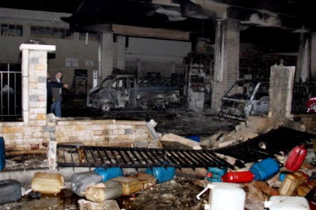 Syrian policemen on Friday inspect the damaged at a fuel station after a car bomb attack at Barzeh area in Damascus. Photo: EPA