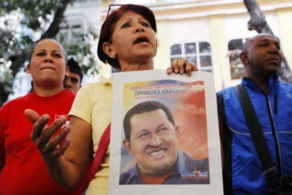 A supporter of Venezuelan President Hugo Chavez holds his picture after attending a ceremony to pray for his health. Photo: Reuters