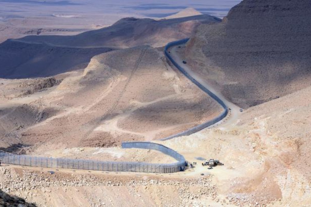 A section of the border fence Israel has erected along its border with Egypt (left). Photo: EPA
