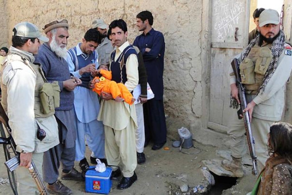 Pakistani security officials escort the heath workers as they administer Polio vaccination to children in Bajaur tribal region near the Afghan border on Wednesday. Photo: EPA
