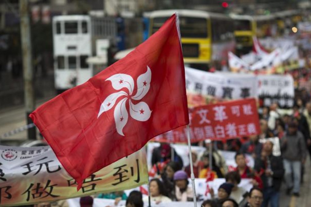 Supporters of Hong Kong's chief executive Leung Chun-ying display a Hong Kong flag and chant slogans during a march in Hong Kong. Photo: EPA