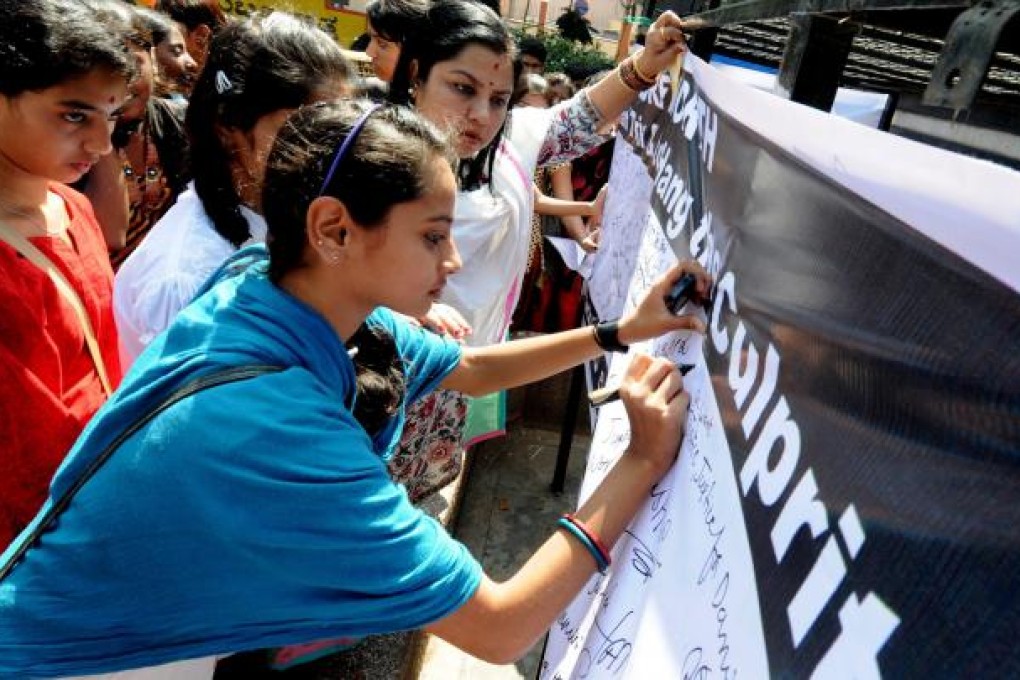 Indian protesters and members of the Akhil Bharatiya Vidyarthi Parishad (ABVP) write a message to Indian Prime Minster during a signature campaign towards violence against women. Photo: EPA
