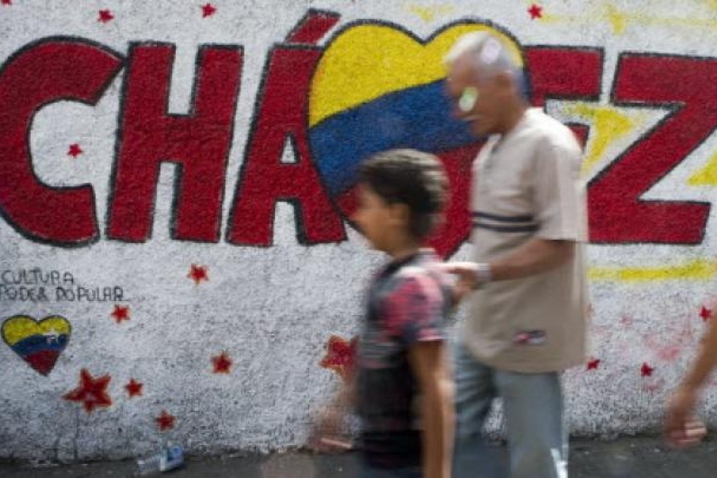 People walk past a graffiti in support of Venezuelan President Hugo Chavez in Caracas. Photo: AFP