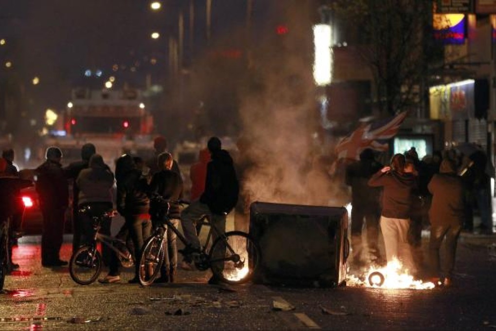 Burning debris blocks the Newtownards Road in East Belfast. Photo: Reuters