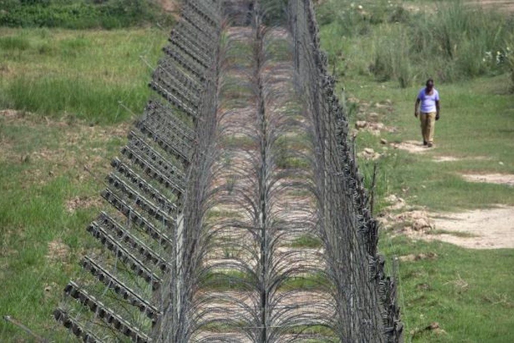 An Indian Border Security Force (BSF) trooper walks near the fenced border with Pakistan in Suchetgarh, southwest of Jammu. Photo: Reuters