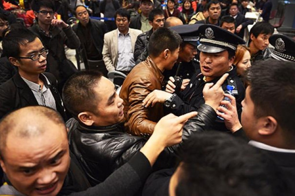 Stranded travellers argue with police at Changshui International Airport in Kunming on Saturday. Photo: AFP